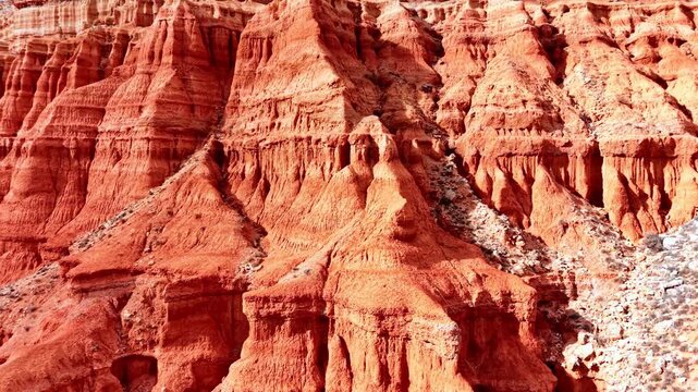 Close up of vertical erosion patterns on a red soil hillside. Texture of eroded red clay formations. Aerial view. Spain canyon.