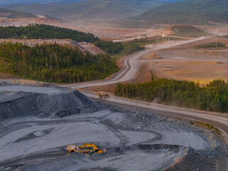 Expansive view of open pit mining site with machinery and winding roads © Parilov