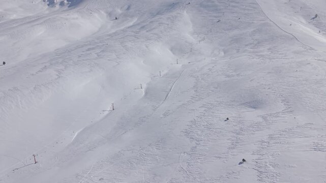 Aerial top-down forward tracking shot gliding over a pure white snow texture background