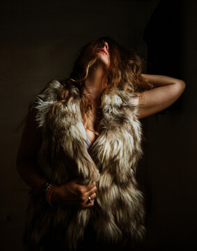 Woman tilting head back in fur coat