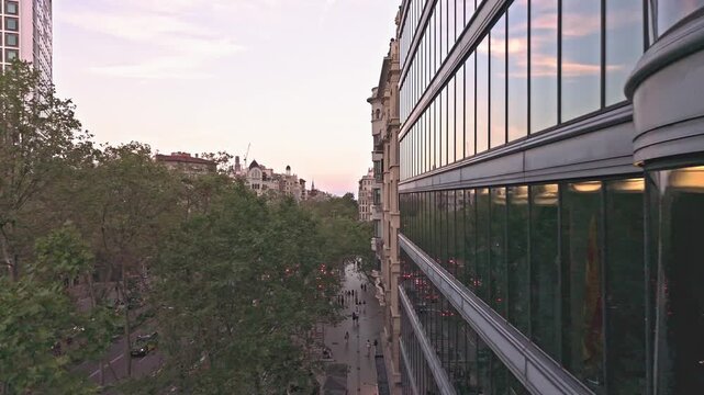 Cinematic aerial drone ascending over barcelona city street at sunset