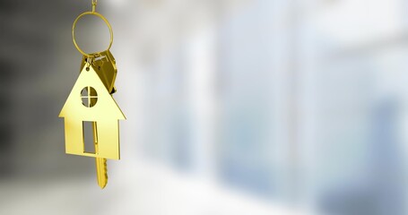 Hanging gold house-shaped keychain pendant and metal keys near left in bright interior, copy space