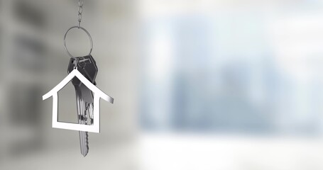 Hanging metal keyring with house-shaped charm and keys on chain in modern interior, copy space