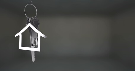 Hanging metal keyring holding several keys and house-shaped keychain at studio backdrop, copy space
