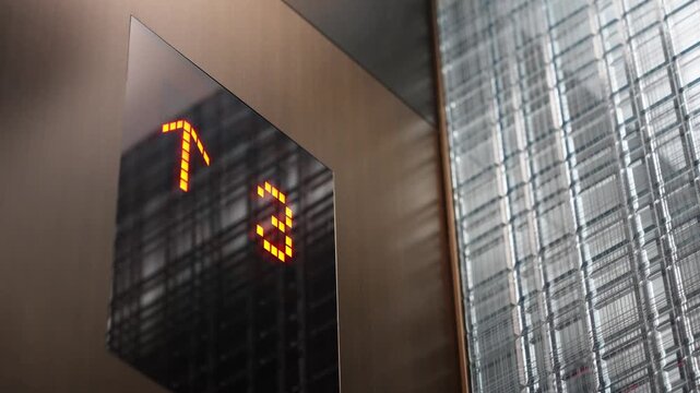Elevator floor indicator displaying upward arrow and number four in illuminated LED digits