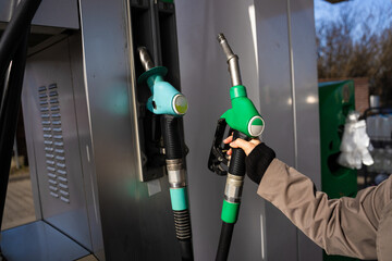 Hand holding gasoline nozzle at fuel station close-up. Driver refueling car using gasoline pump © Rabizo Anatolii