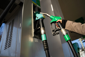 Close-up of hand holding petrol nozzle at gas station © Rabizo Anatolii