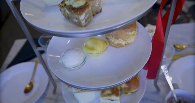 Steady cam, closeup shot lowering on tower of plates with snacks and sandwiches