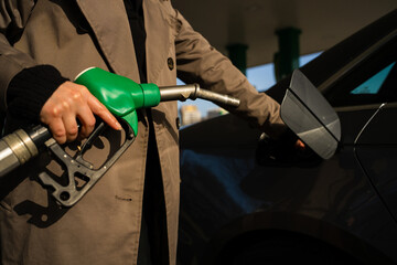 Close-up of hand refilling vehicle with gasoline. Fuel pump inserting into tank during refueling © Rabizo Anatolii