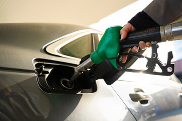 Petrol pump nozzle inserted into vehicle fuel tank close-up © Rabizo Anatolii