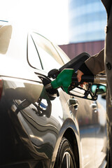 Gasoline dispenser nozzle refilling vehicle fuel tank © Rabizo Anatolii