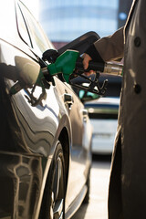 Driver using petrol pump nozzle to refill car tank © Rabizo Anatolii