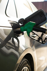 Hand refilling vehicle fuel tank with pump nozzle © Rabizo Anatolii