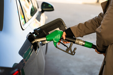 Fuel pump inserted into tank during refueling. Close-up of hand refilling vehicle with gasoline © Rabizo Anatolii