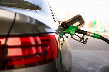 Close-up refilling vehicle with gasoline. Fuel pump inserted into tank during refueling © Rabizo Anatolii