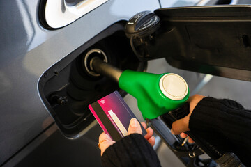 Hand holding bank card near gasoline nozzle during refueling © Rabizo Anatolii