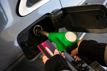 Card held near petrol pump during car refueling © Rabizo Anatolii