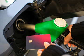 Card held near petrol pump during car refueling © Rabizo Anatolii