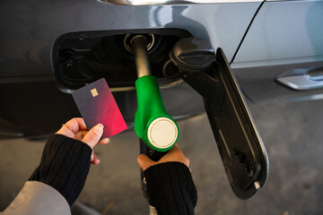 Card held close to petrol pump during vehicle refueling © Rabizo Anatolii