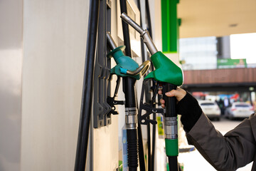 Fuel pump nozzle in hand while refueling vehicle © Rabizo Anatolii