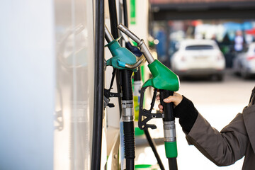 Hand holding gasoline nozzle at fuel station close-up. Driver refueling car using gasoline pump © Rabizo Anatolii