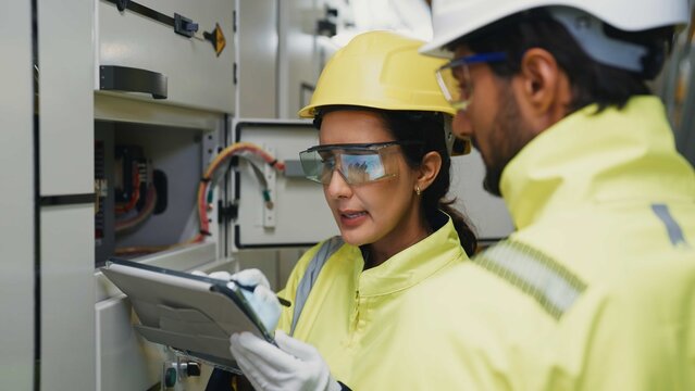 Two engineers confer on tablet to schedule preventive maintenance and assign service tasks for refrigeration equipment.
