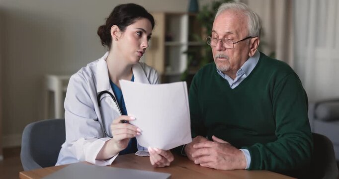 Doctor reviewing medical results with senior man patient during consultation, explaining treatment plan or important health information, clarifying insurance conditions and terms. Healthcare services