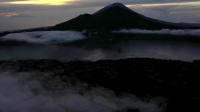 Bali, Indonesia &ndash; Drone Slowly Rolling Up Toward Mount Abang at Sunrise Above Cloud Inversion