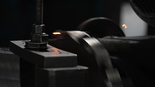 Industrial lathe machining metal parts with flying sparks during operation