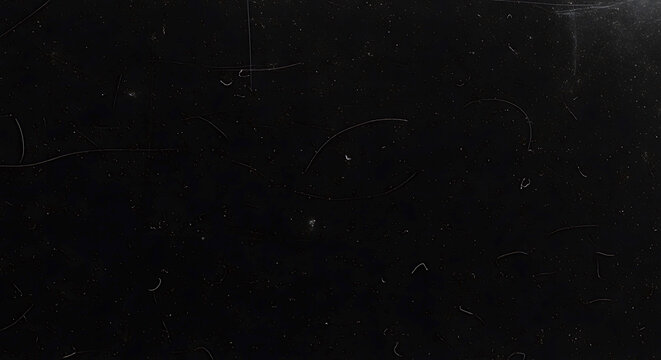 A black surface with scratches and marks on it