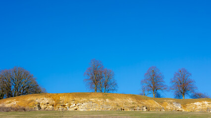 The mysterious underground coal mine in Valkenburg, Winter landscape featuring rock cliffs, wooded and hillsunder blue sky, Historic subterranean cavern in the Dutch province of Limburg, Netherlands.