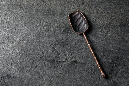 Bronze scoop on gray textured table, top view. Space for text