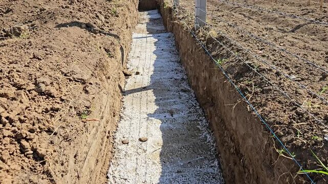 Reinforced concrete strip foundation in a construction site trench