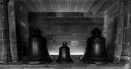 Obraz premium Three church bells in stone alcove, black and white