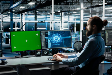Obraz premium Data center technician using green screen PC, adjusting AI model parameters to upgrade systems. Man in server room using mockup computer, scheduling deep learning maintenance for hardware components