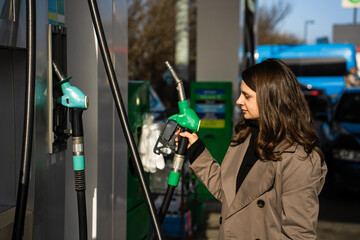 Woman holding gasoline nozzle while refueling car at petrol station © Rabizo Anatolii