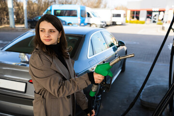 Fuel pump inserted into tank during refueling. Close-up of hand refilling vehicle with gasoline © Rabizo Anatolii