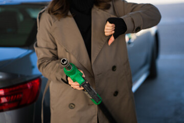 Holding gasoline nozzle and signaling price drop © Rabizo Anatolii