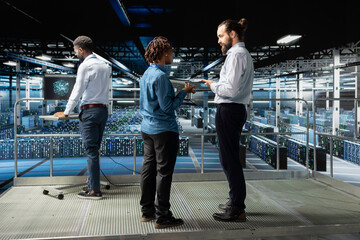 Obraz premium Data center engineers team performing maintenance on supercomputers with artificial intelligence. Server room staff members upgrading rigs used for machine learning, software engineering.