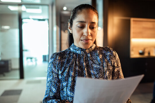 Professional woman reviewing paperwork in modern office