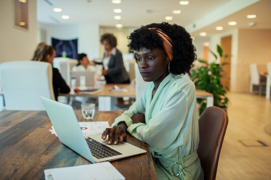 Focused businesswoman working on laptop in modern office