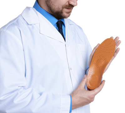 Orthopedist in medical coat with foot insole on white background, closeup