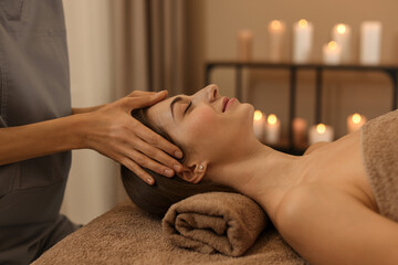 Beautiful woman receiving facial massage on couch indoors, closeup