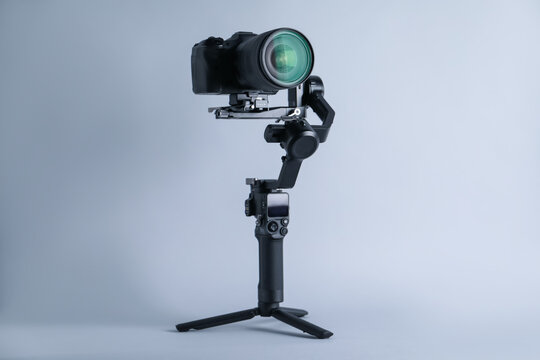 Gimbal stabilizer with camera on light background