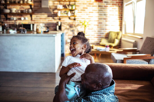 Grandfather playing with granddaughter at home
