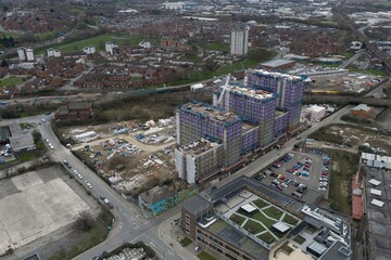 Fototapeta premium Drone aerial view of Bridgewater Place overlooking River Aire and Leeds Dock with waterfront warehouses offices and city skyline beneath cloudy sky