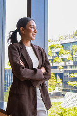 Fototapeta premium Smiling asian businesswoman using mobile phone in modern office. Business asian woman using mobile phone during checking an email or social media on internet. accounting financial concept.