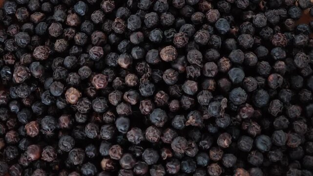 Black peppercorns herb in a wooden plate.