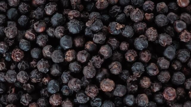 Black peppercorns herb in a wooden plate.