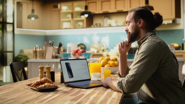 Adult man checking new smartphone product presentation and reveal online on laptop, high tech announcement with modern features. Tech review and comparison, advanced phone coming soon.